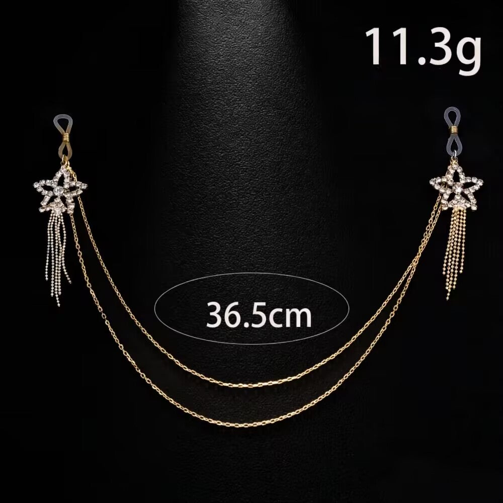 Product display of a one-piece gold fake piercing star tassel body chain set weighing 11.3g and 36.5cm in length with adjustable silicone loops.