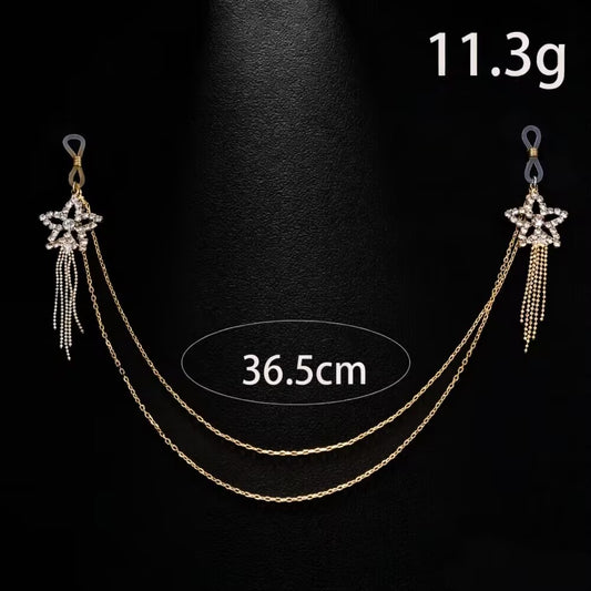 Product display of a one-piece gold fake piercing star tassel body chain set weighing 11.3g and 36.5cm in length with adjustable silicone loops.