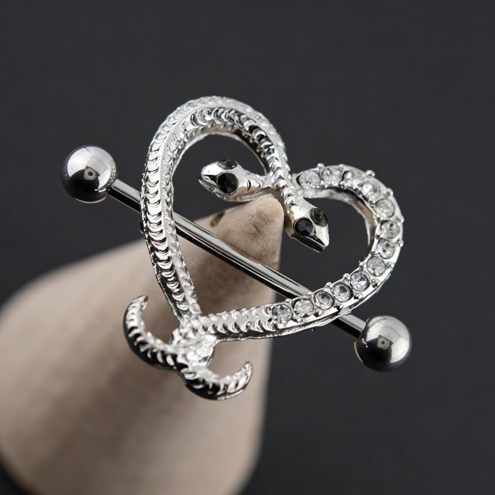 Aesthetic close-up of a silver crystal snake nipple piercing on a jewelry display.