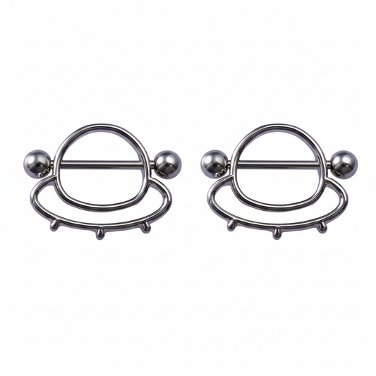 A pair of alien spaceship nipple shield rings for body piercing decoration.