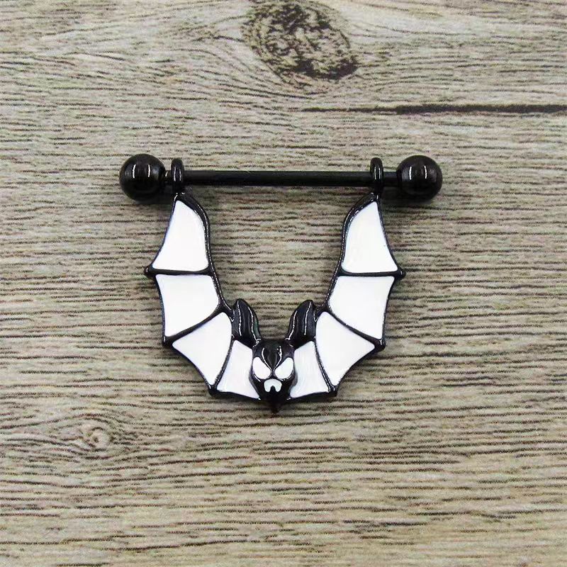 Bat nipple shield piercing jewelry displayed on a rustic wooden background.