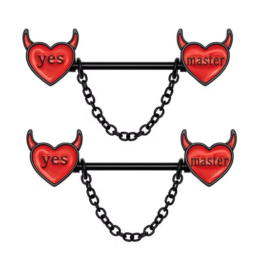 A pair of black nipple barbells featuring red enamel devil hearts with "yes" and "master" text and hanging chains.
