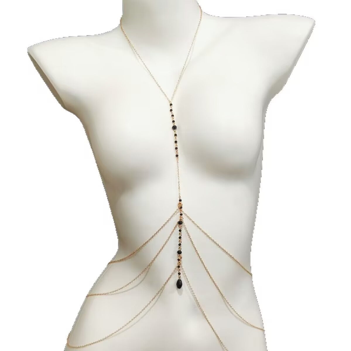 Gold layered body chain jewelry featuring dangling teardrop crystal pendants on a mannequin.