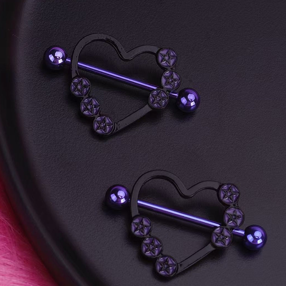 Close up of gothic purple heart nipple shields on a dark textured surface