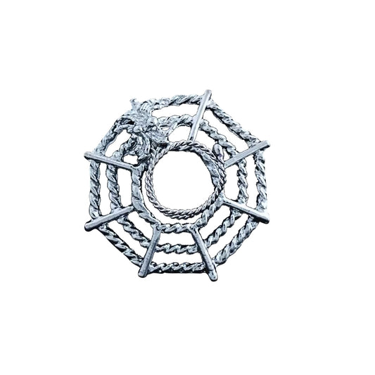 Detailed silver-tone spider web nipple shield with a small spider on a white background, featuring a circular center for piercings.
