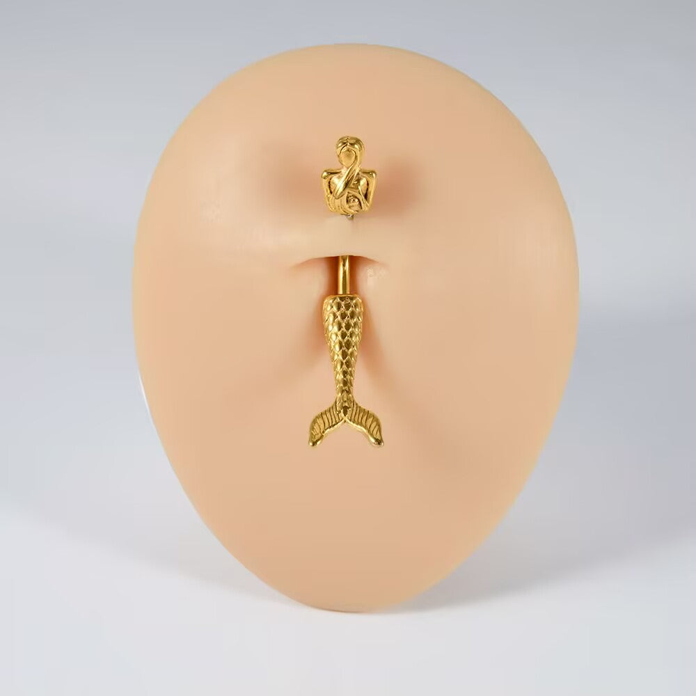Gold mermaid navel ring fitted on a silicone body display model showing natural placement and fit.
