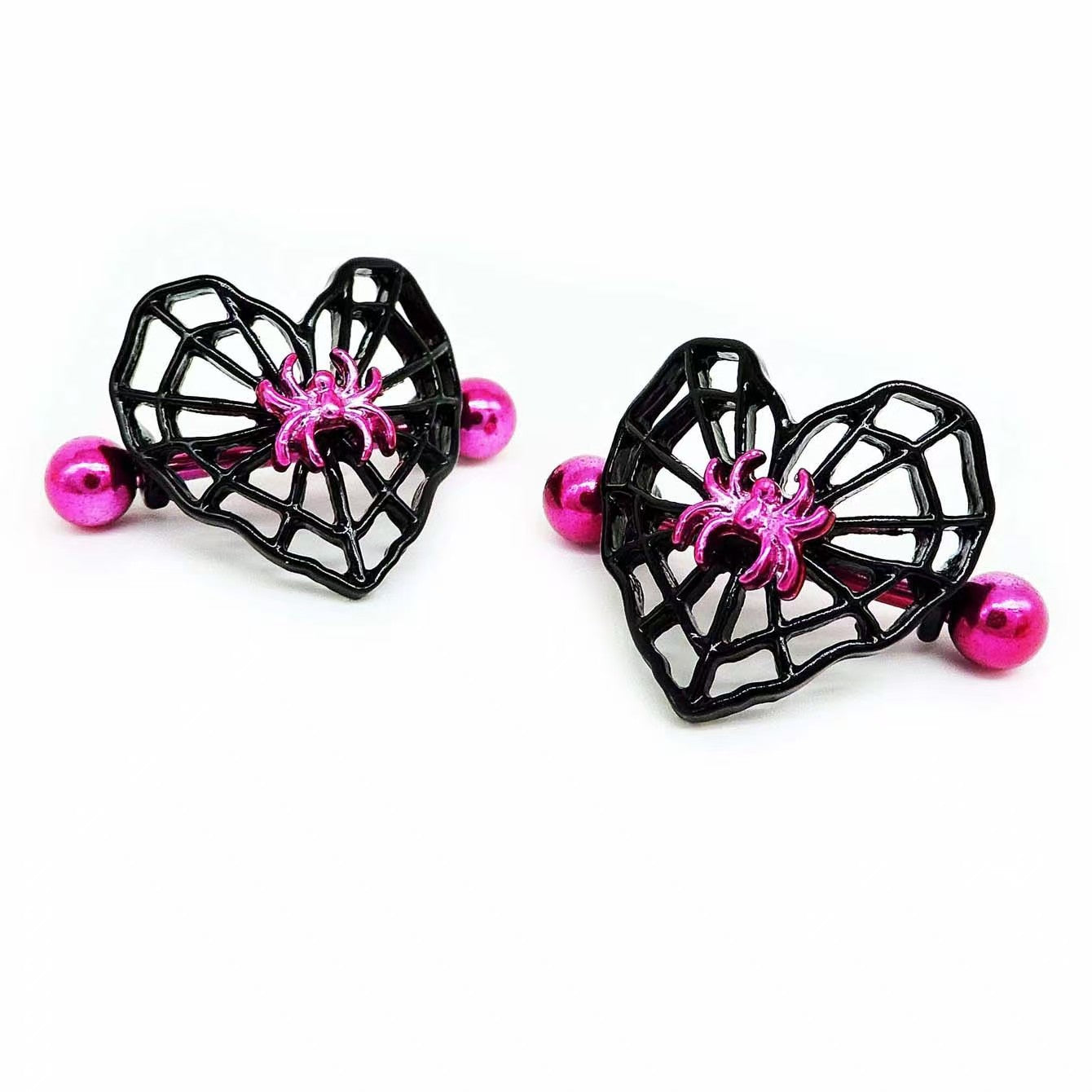 A pair of gothic style nipple piercings featuring black heart-shaped webs and vibrant pink spider charms.