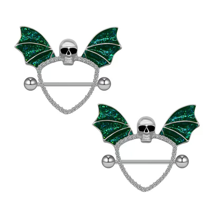 A matching pair of sparkly green bat wing nipple shields with skull detail on a white background.