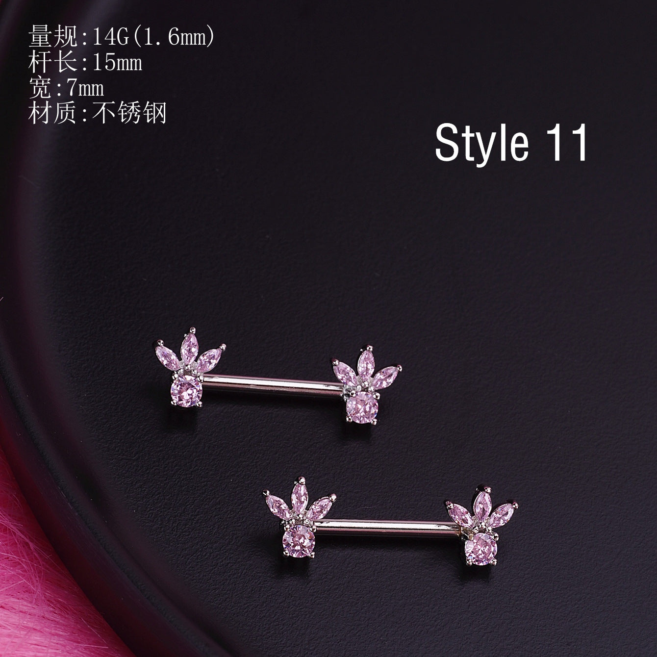 A product display of pink marquise-cut crystal nipple barbells with size specifications 14G and 15mm length on a black textured surface.