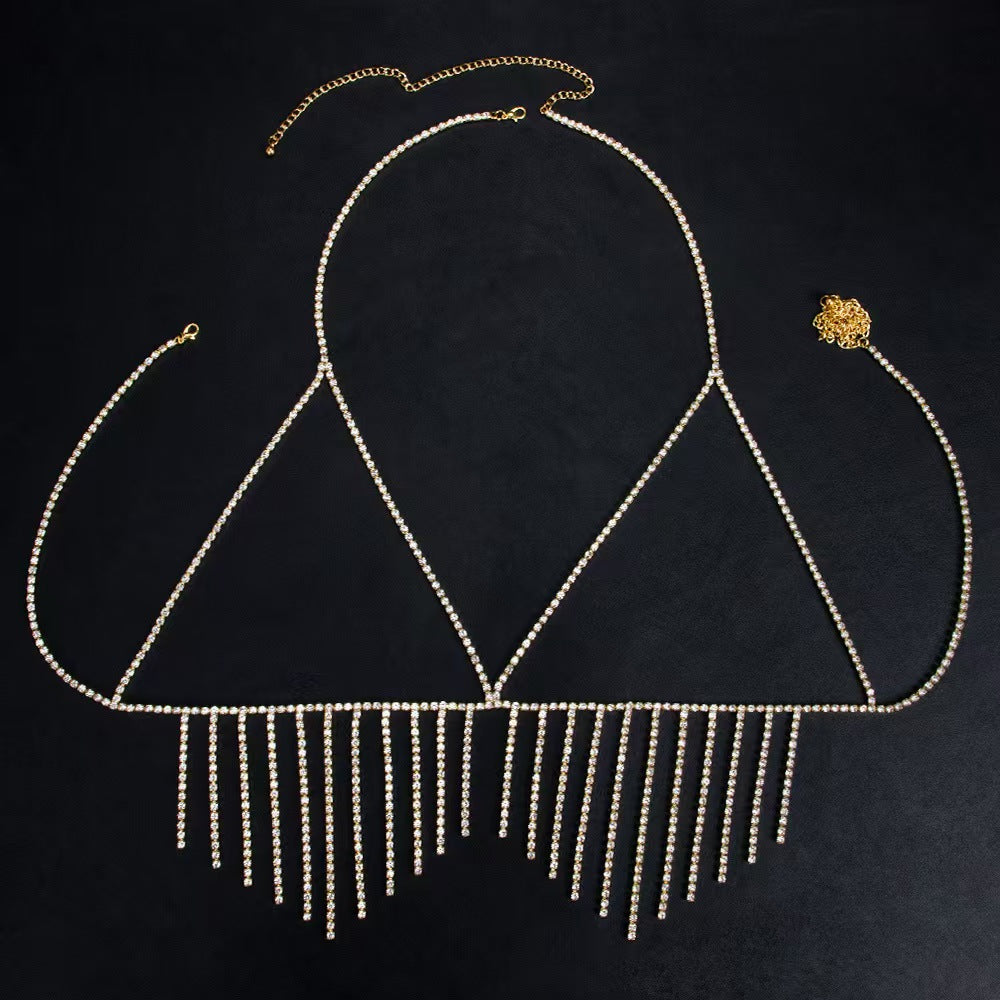 Premium gold crystal fringe statement body jewelry laid out on a dark black surface, emphasizing the shining metal hardware and detailed craftsmanship of the adjustable extension chain.