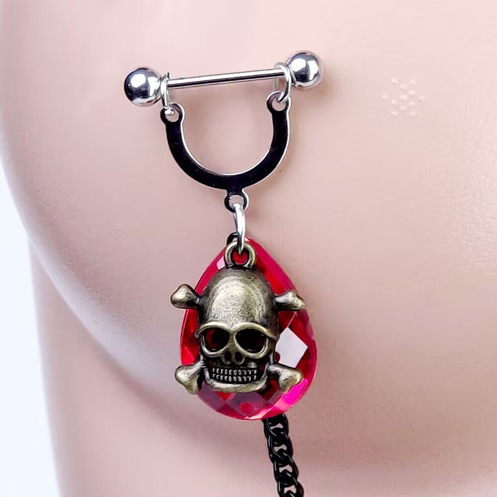 Red teardrop crystal nipple ring adorned with a vintage skull charm worn on mannequin.