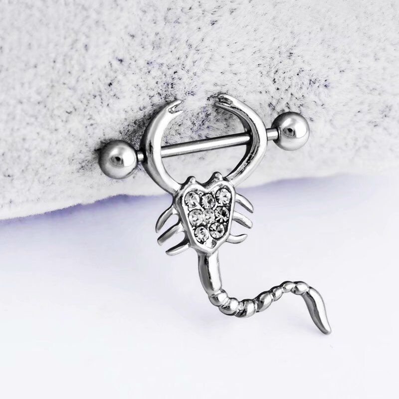 Close-up shot of a scorpion nipple ring showing intricate design details.