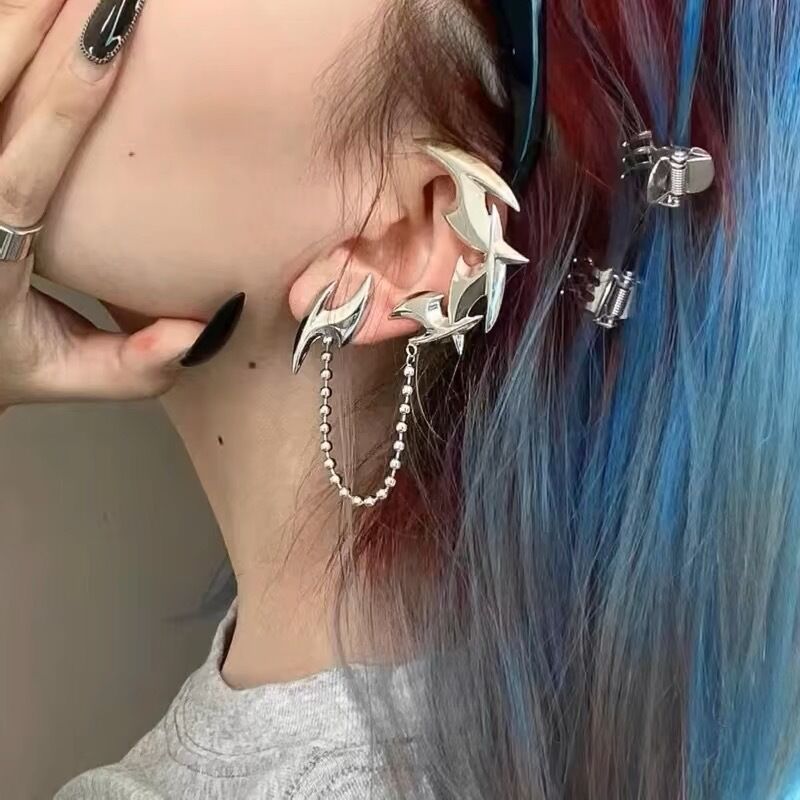Alt fashion model wearing liquid metal flame ear cuff with chain for Y2K wasteland style