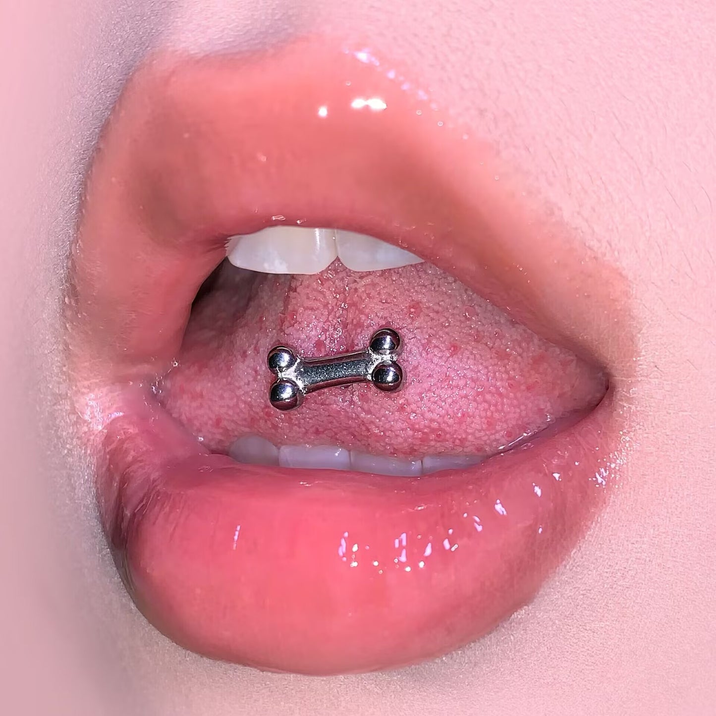 Close-up view of a 14G 316 steel bone tongue piercing barbell featuring smooth fit on tongue