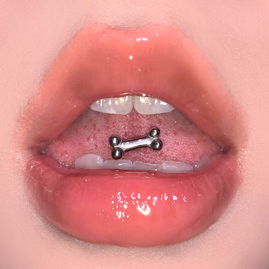 High-polish 316 stainless steel dog bone tongue ring worn on tongue showing flat front fit