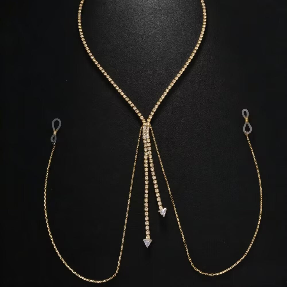 Flat lay product display of a gold rhinestone non-piercing nipple chain body jewelry on a black background, showing the adjustable transparent silicone loops and rhinestone drop pendants.