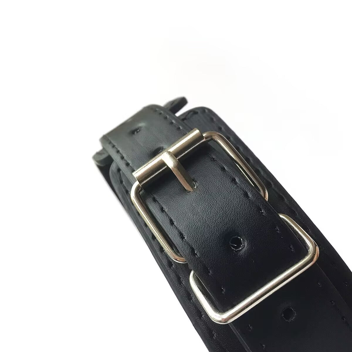 Detailed view of the silver metal pin buckle and eyelets on the premium black leather collar for size adjustment.