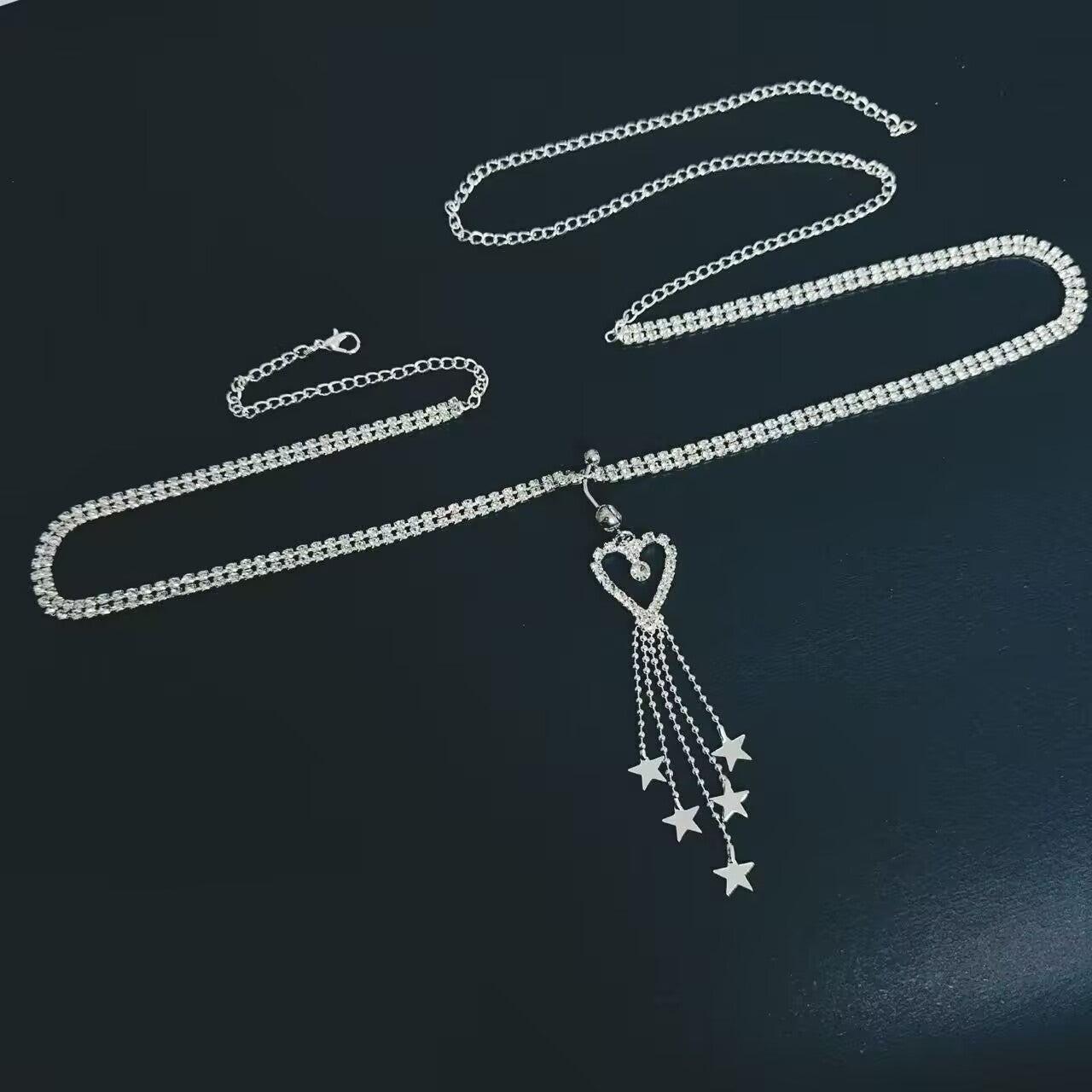 Full view of heart and star rhinestone belly button ring with lobster clasp extension waist chain.
