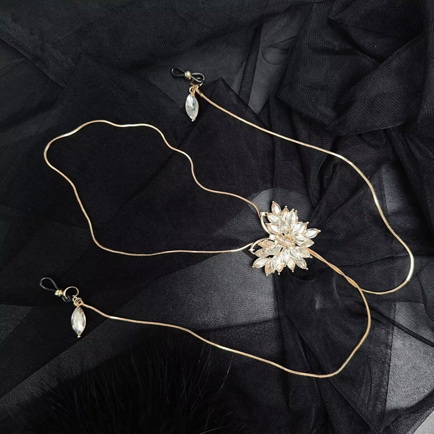 Flatlay view of fake nipple piercing body chain showing adjustable silicone rubber loops and dangle crystal charms