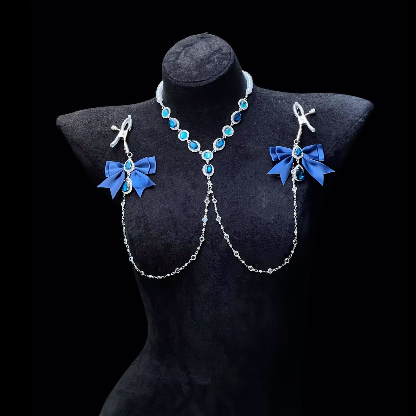 Close-up shot of the adjustable screw-on body jewelry with hanging chains and deep blue statement crystals.