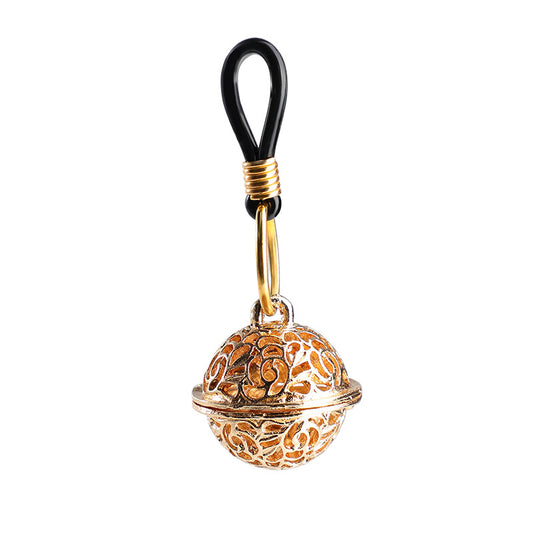 A gold-toned hollow filigree sphere charm hanging from an adjustable black sensory loop for intimate wear.