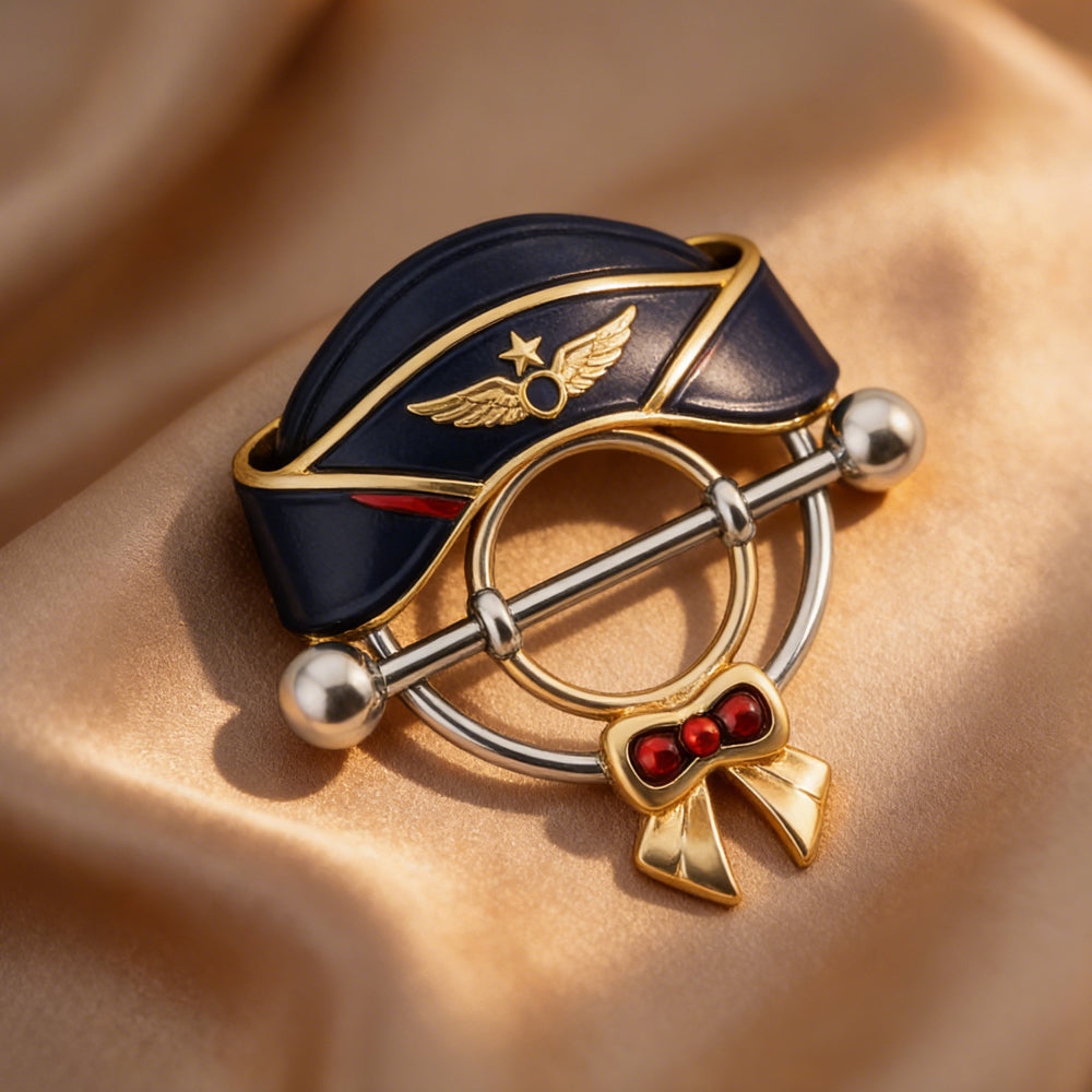 Luxury lifestyle shot of aviation-themed nipple jewelry on gold satin background.
