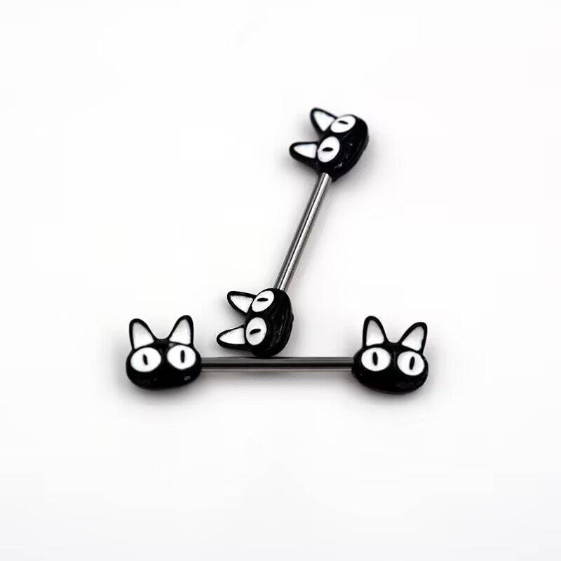 Close-up shot of two black kitten nipple rings with big white eyes arranged on a white background.