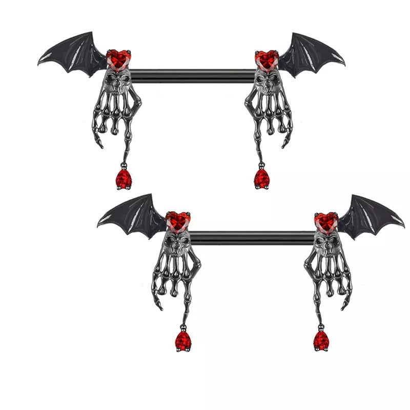 Pair of bat wing nipple barbells with skeletal hand charms, red hearts and dangling red drops.