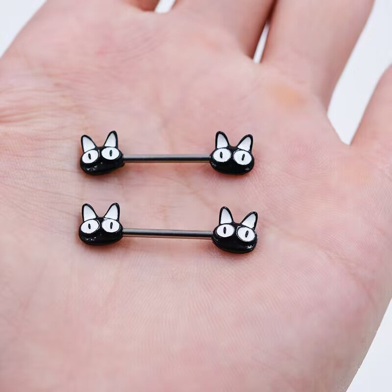 Real-life scale of two black cat nipple barbells held in a hand to show the cute anime kitten design.
