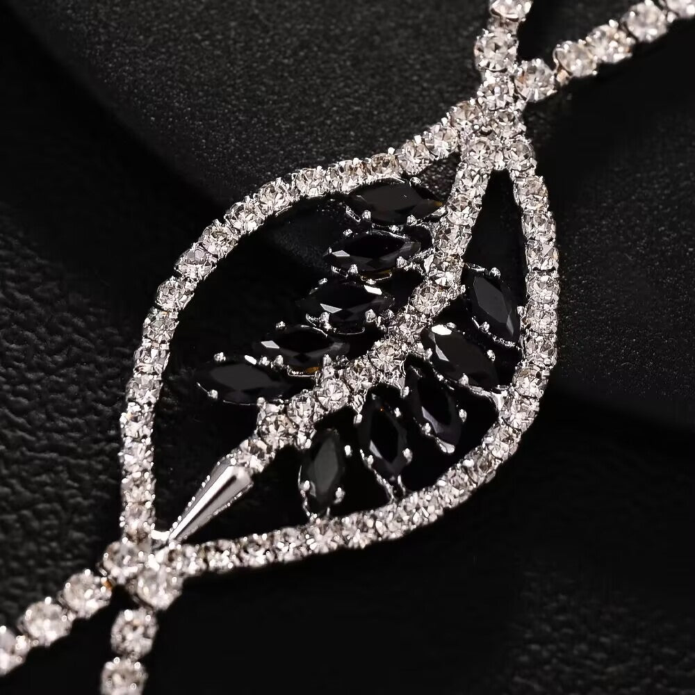 Close-up of the black crystal marquise stone leaf pendant surrounded by sparkling clear rhinestones.