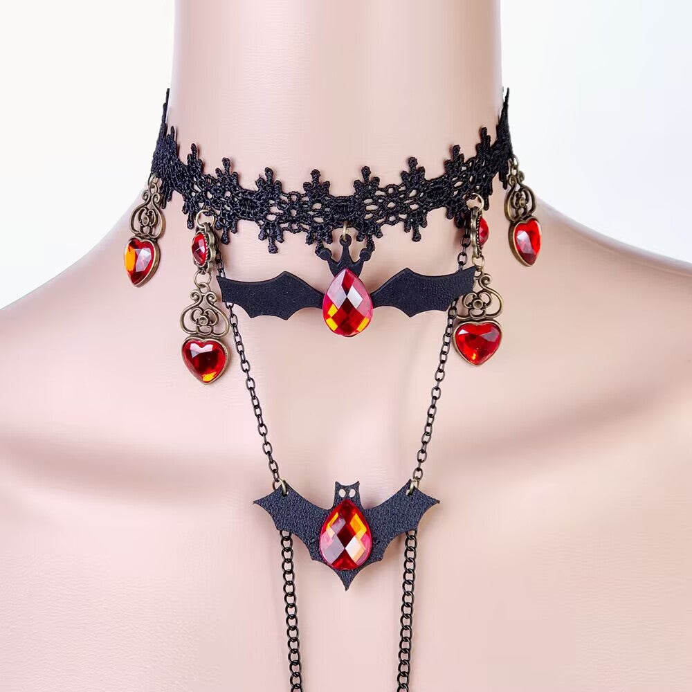 Close-up of black lace choker necklace with dark bat charms and faceted red crystal ruby droplets