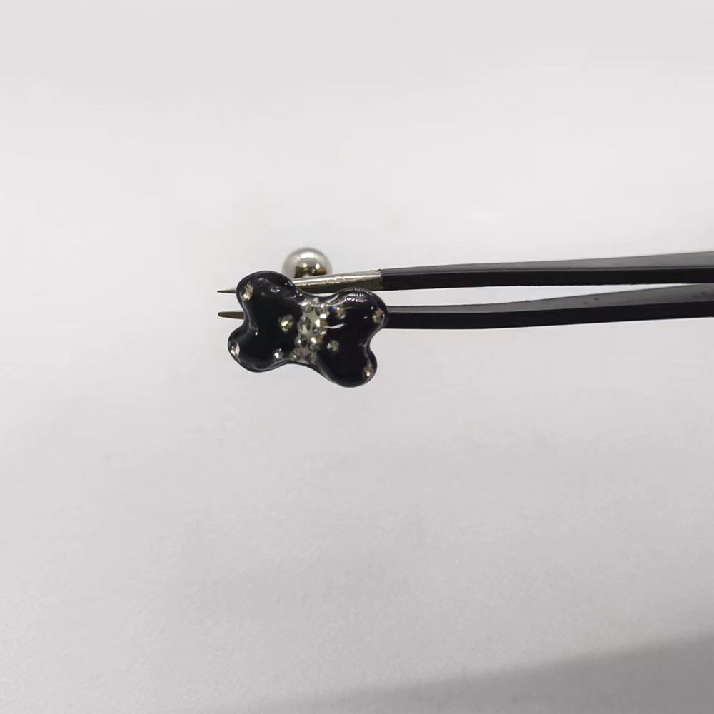 One Black butterfly tongue barbell held with tweezers, featuring clear rhinestone accents and a metal ball end.