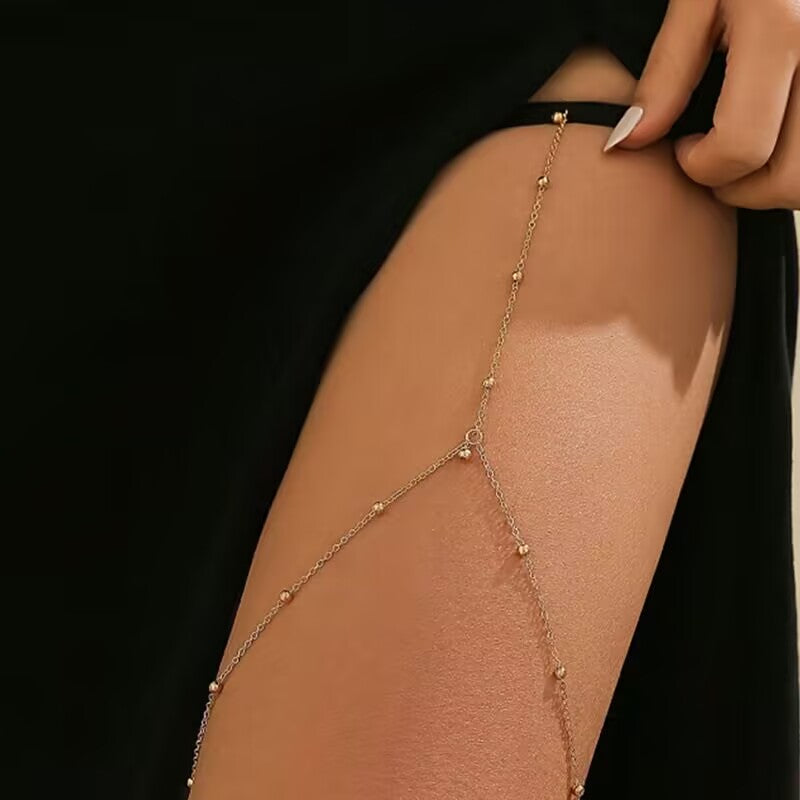 Boho style gold beaded thigh chain leg jewelry with black stretch band on female model