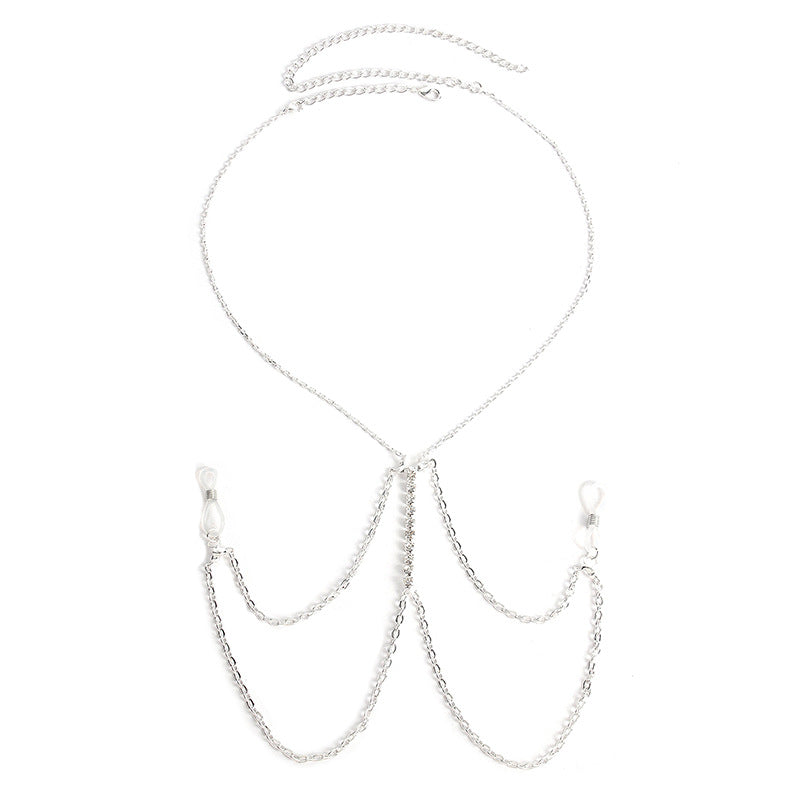 Symmetrical flat lay of a multilayer tassel body chain on a textured black background.