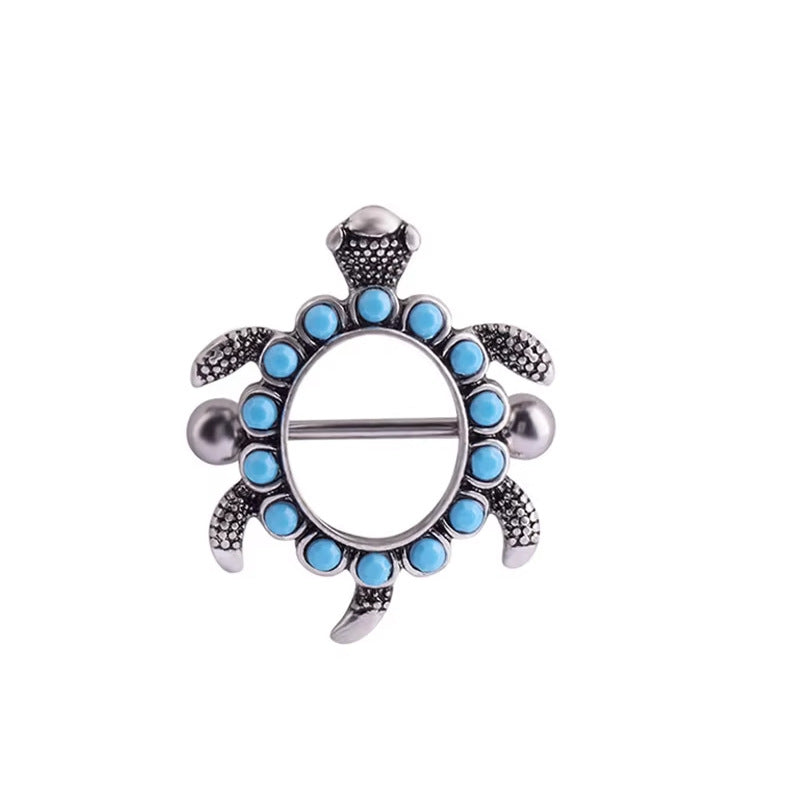 Front view of a silver-tone sea turtle nipple shield decorated with circular turquoise beads.