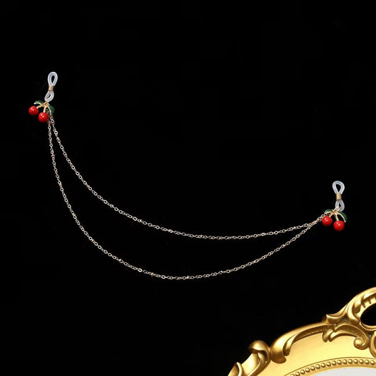Cherry fake nipple ring chain with clear silicone loops laid flat against a black background