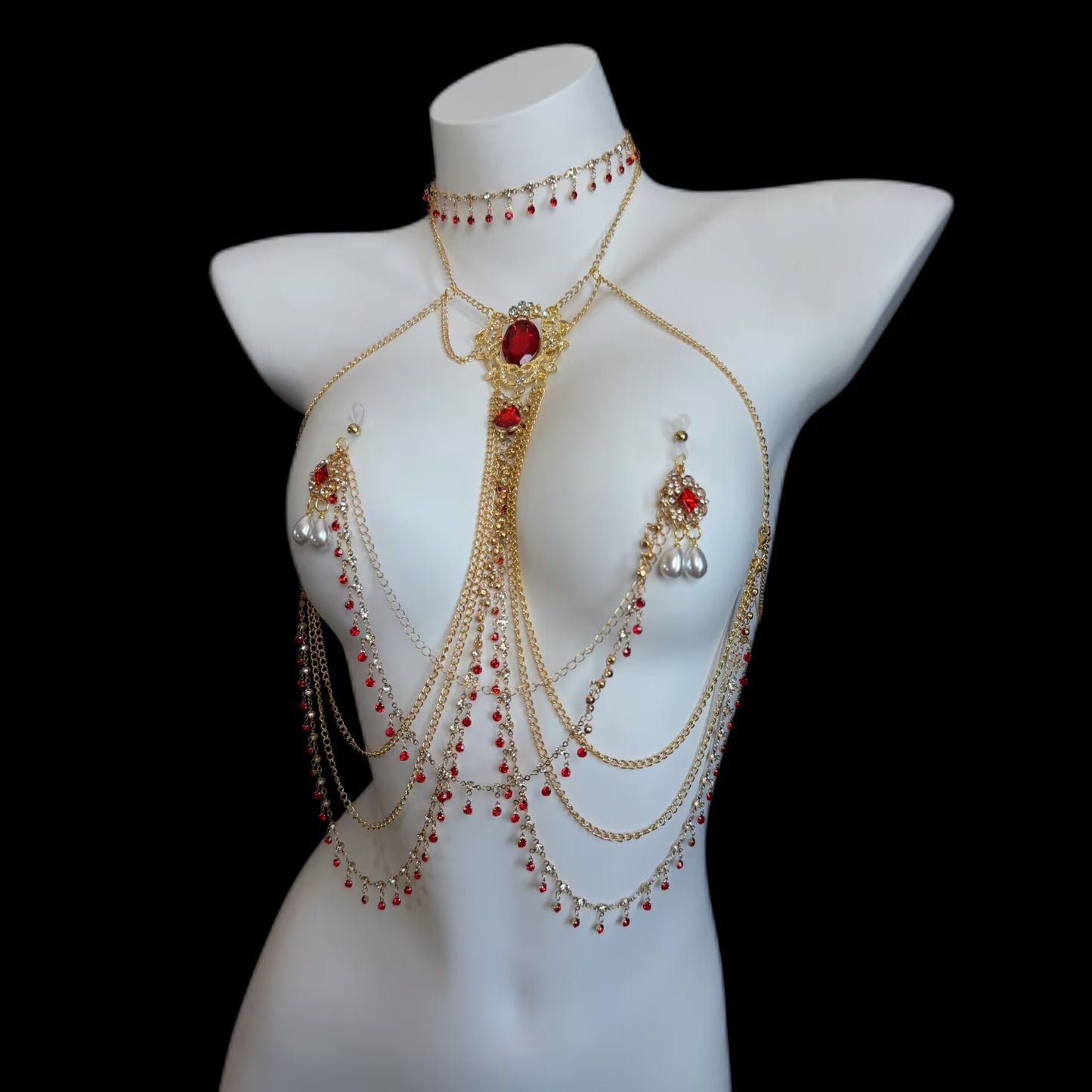 Full view of gold multi-layer chest body chain paired with non-pierced suction cup nipple jewelry featuring red crystal filigree pendants and teardrop pearls.