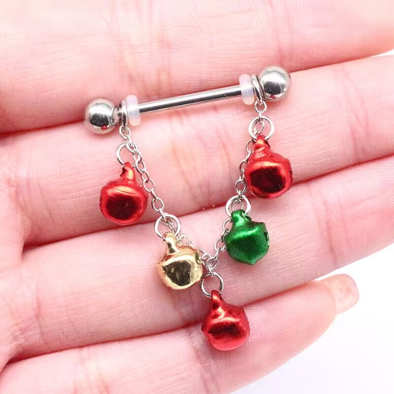 Close-up of a Christmas bell dangle nipple barbell held in hand showing gauge size and bell charms