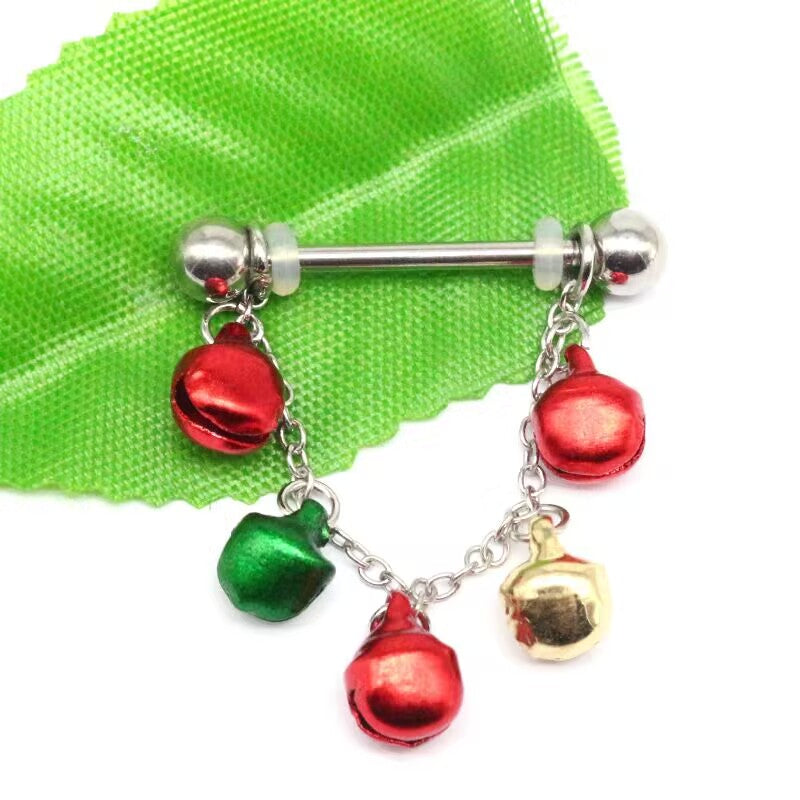 Christmas jingle bell nipple ring with red, green, and gold bell charms on green fabric background