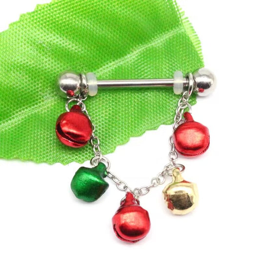 Christmas jingle bell nipple ring with red, green, and gold bell charms on green fabric background