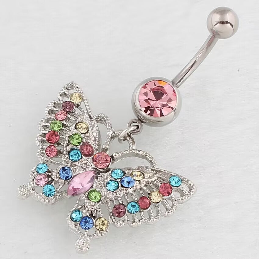 Macro close-up shot showing the detailed openwork filigree and multi-colored stones on the butterfly dangle navel jewelry.