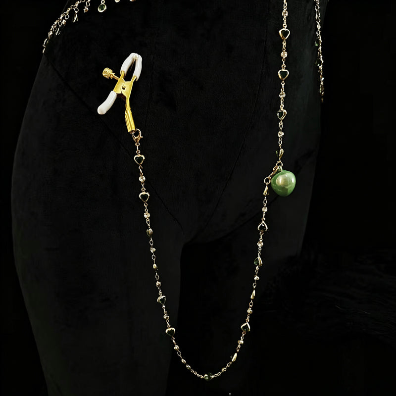 Close-up detail of non-pierced nipple clamp attached to a delicate green crystal heart chain