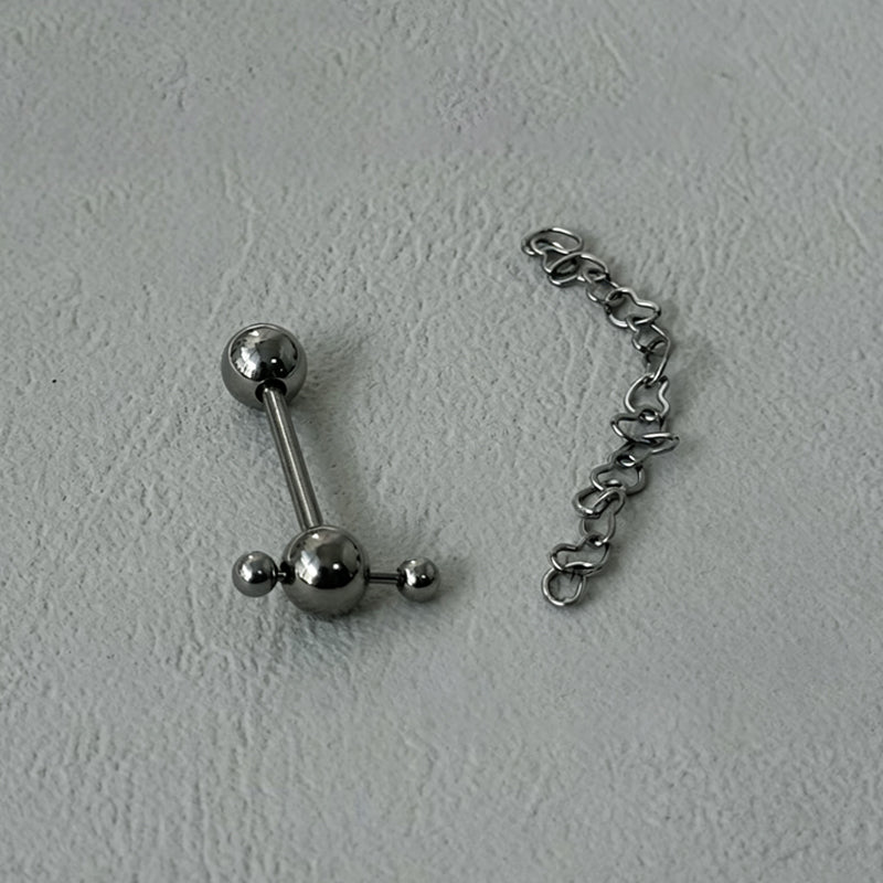 Cross barbell tongue ring alongside detachable heart-shaped chain accessory