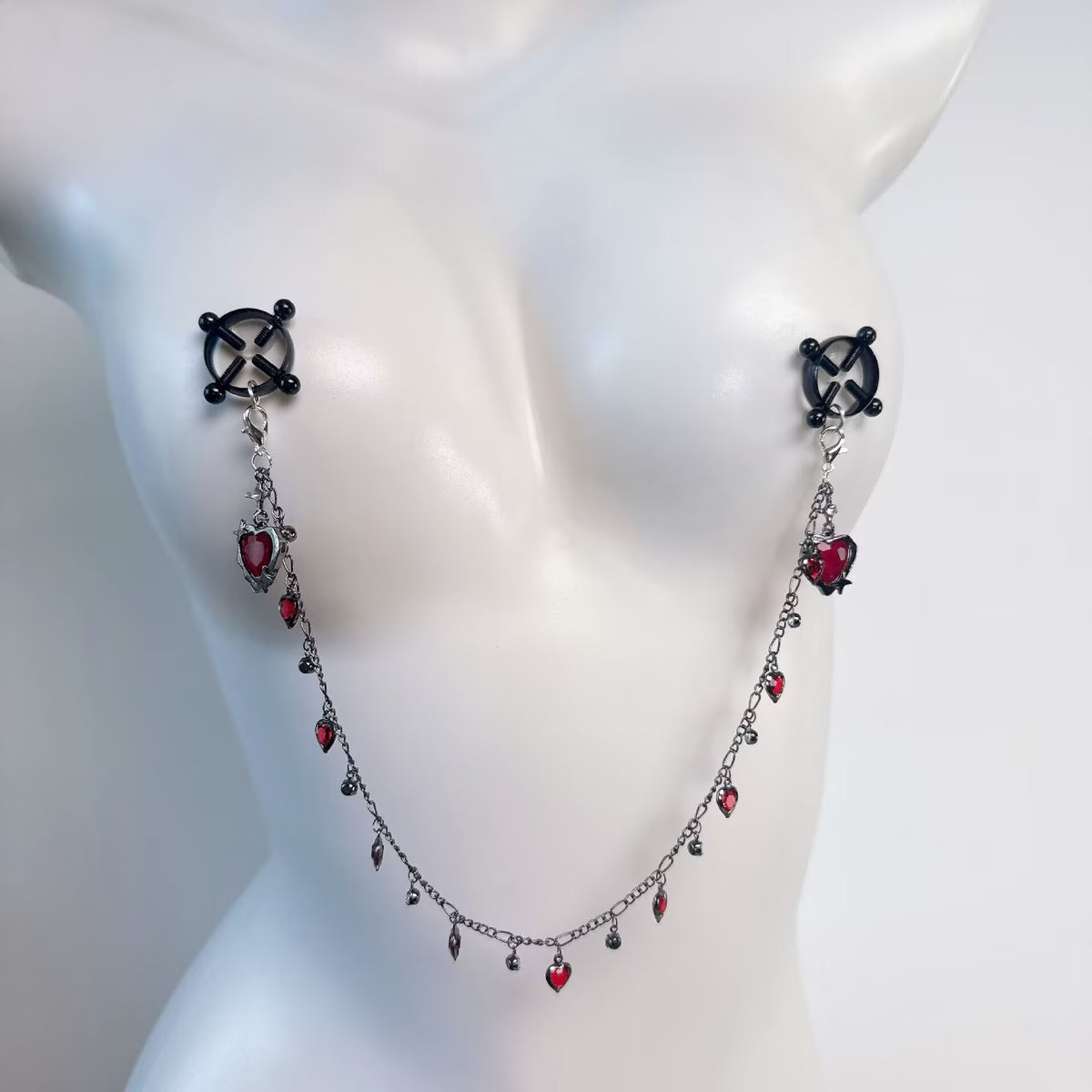 Cross design non-pierced nipple shield clamps connected by a red crystal heart body chain
