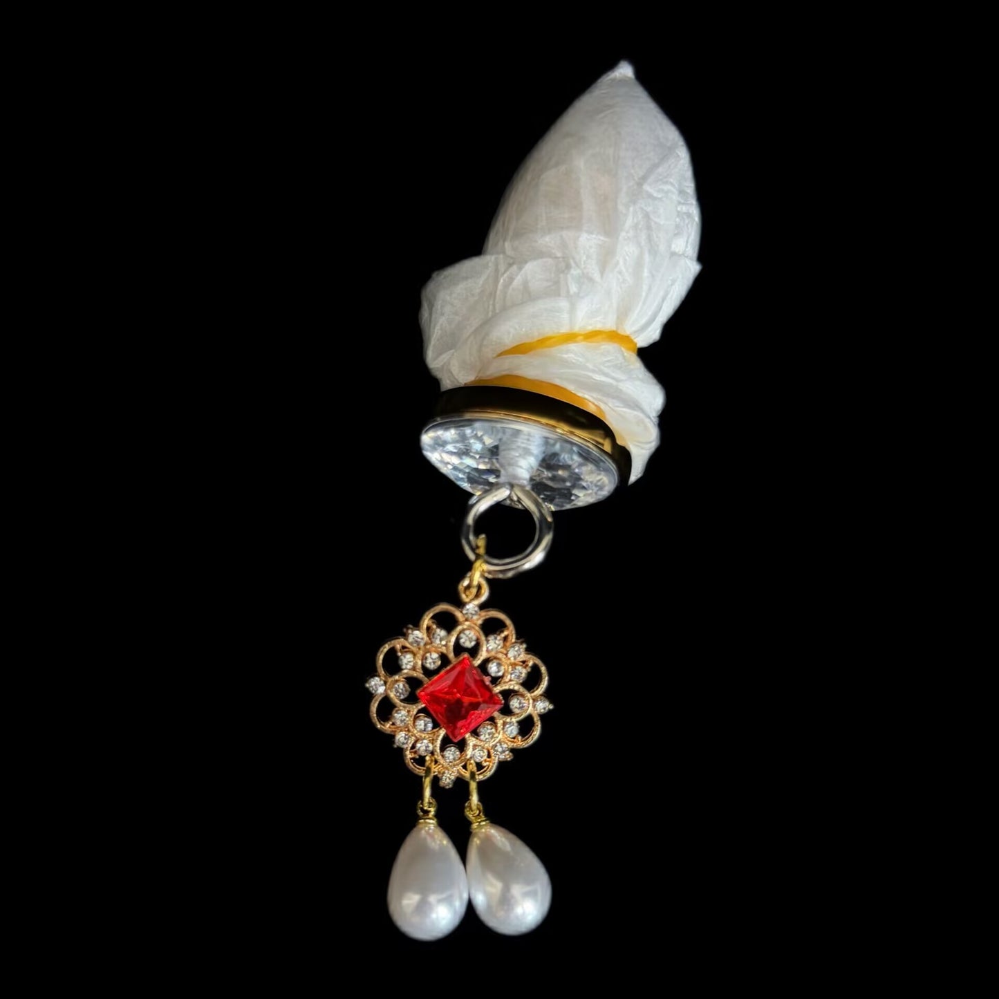 Body-safe crystal glass butt plug with a sparkling base attached to a decorative gold filigree pendant with red rhinestone and teardrop pearls.