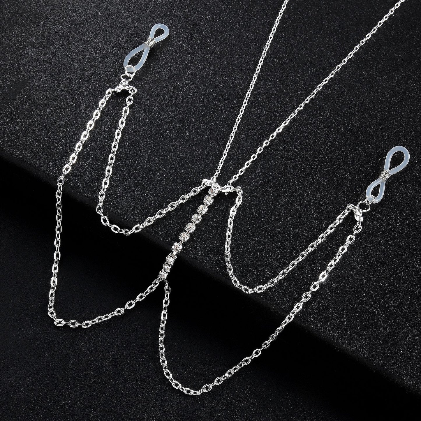 Close-up of crystal-encrusted vertical bar pendant on a layered metal body chain.