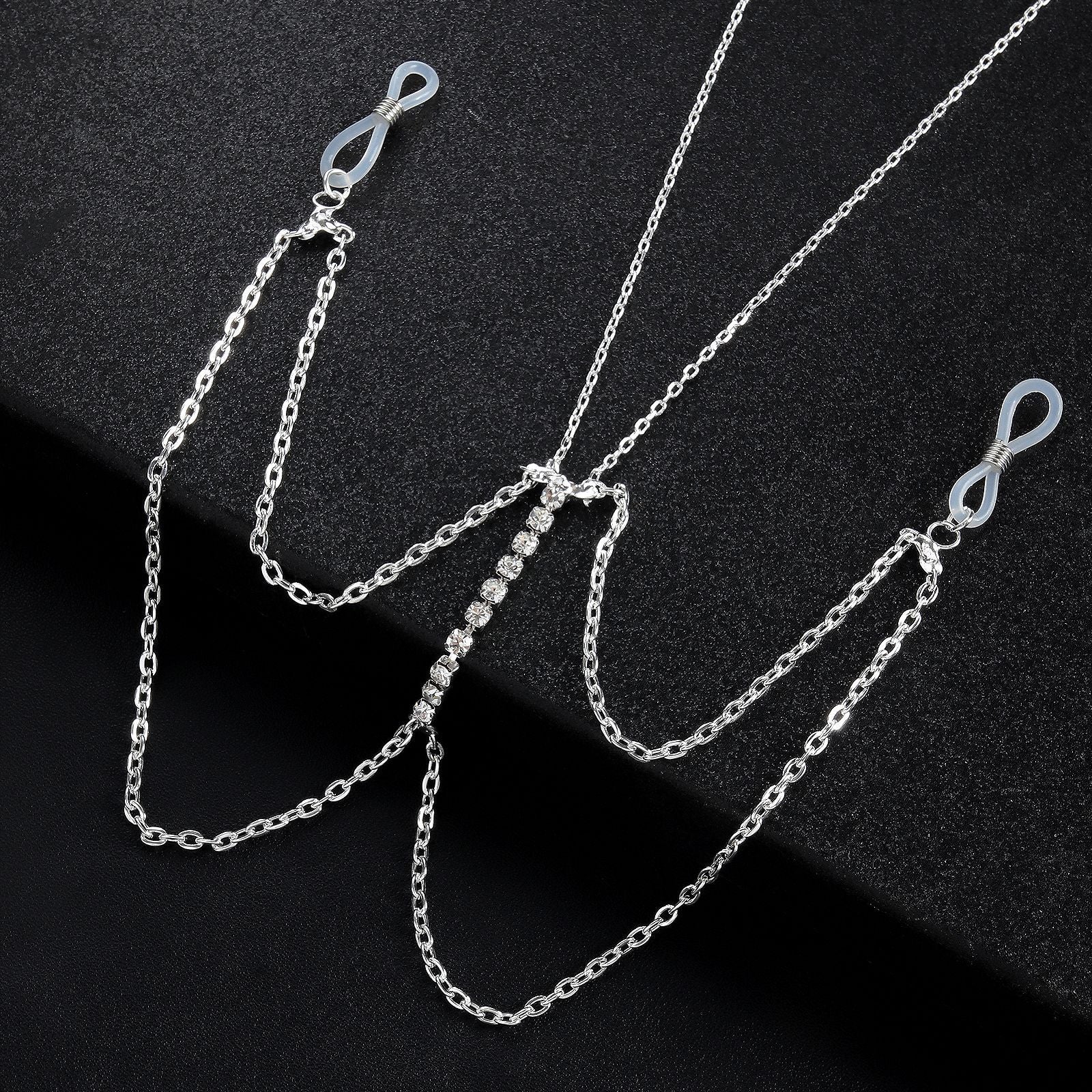 Close-up of crystal-encrusted vertical bar pendant on a layered metal body chain.