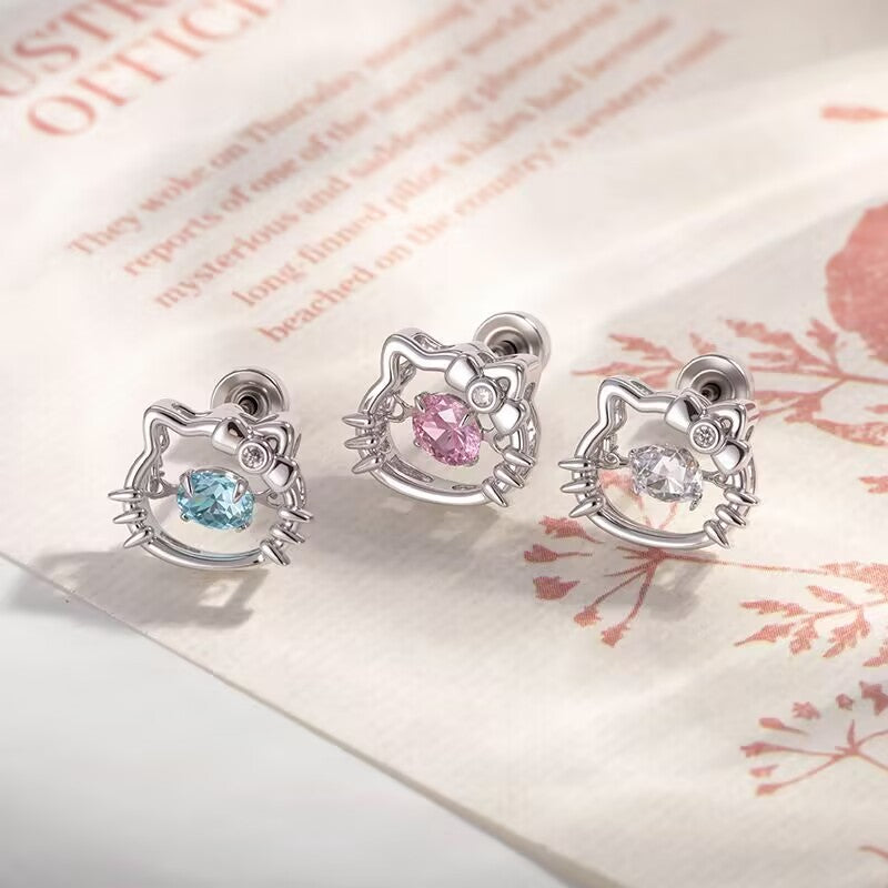 Trio of dancing crystal kitty flat back stud earrings with blue, pink, and clear cz stones on background