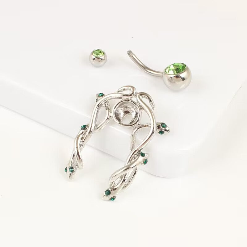 Disassembled view showing the detachable snake belly ring jacket frame alongside the curved navel barbell and green CZ top ball.