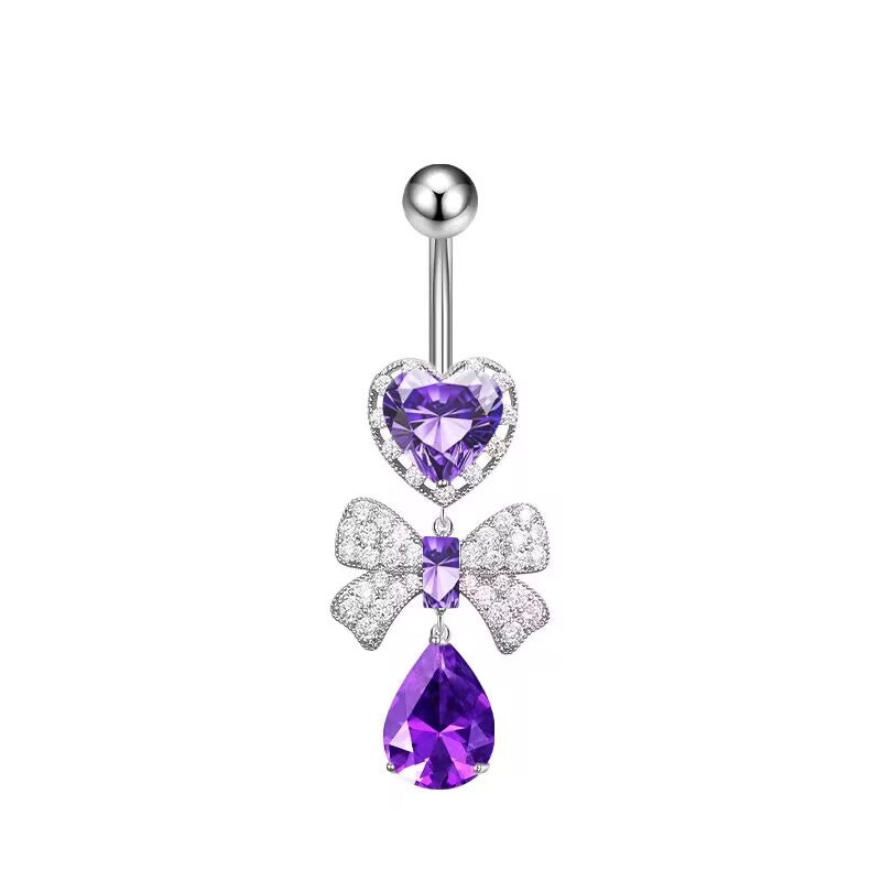 Dreamy purple crystal heart and rhinestone bowknot dangle navel ring on a white background.